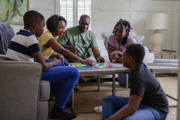 Black army family playing board games at home