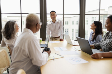 Mature Asian man leading business team meeting