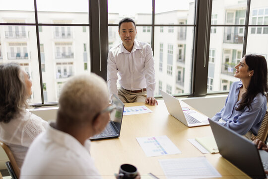 Mature Asian man leading business team meeting