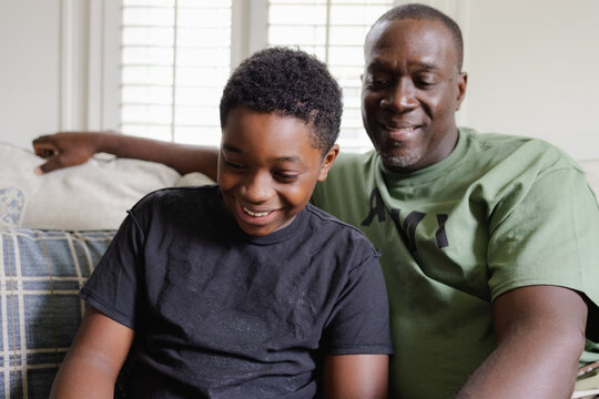 Black father helps son with homework, happiness