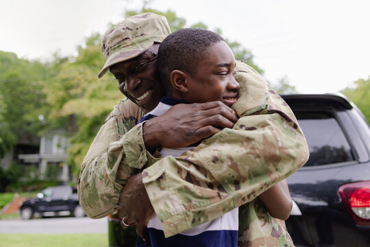 Black military man embraces son as he is welcomed home
