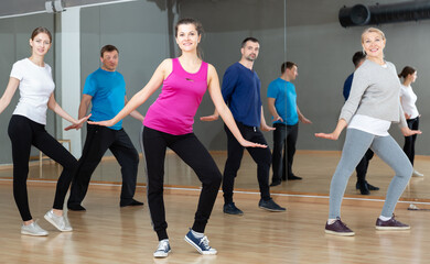 Fototapeta na wymiar Dance class for adult people, positive young and mature men and women training in dance studio
