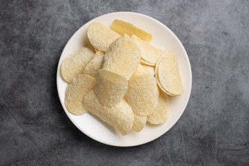 Top view potato chips in white bowl on loft cement background, Close up....