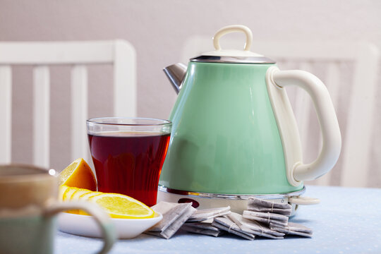 Electric kettle, tea bags, hot tea, sliced lemon. Household kitchen appliances for making hot drinks