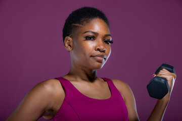 Black woman doing workout with dumbbells 