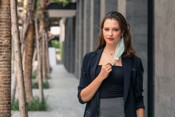 Fototapeta premium woman taking off face mask in concept of hope for coronavirus covid 19 pandemic end