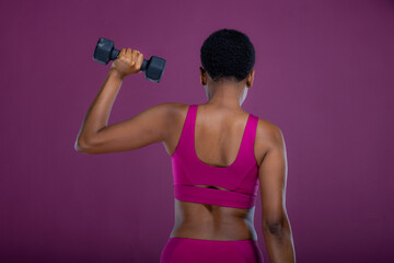 Rear view of Black woman doing dumbbell exercises 