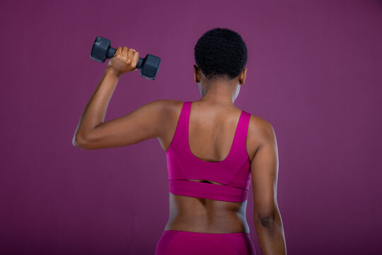 Rear View Of Black Woman Doing Dumbbell Exercises 