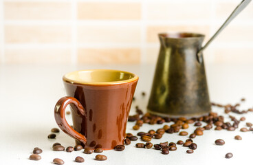 Old rare Scandinavian cup brown color of baked clay, standing next to the coffee pot, which prepared the coffee EST and milk dish is on the table. arabica coffee beans are scattered