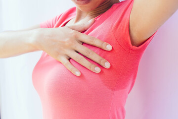 An Asian woman with profuse sweating. A condition in which the body sweats abnormally through the...