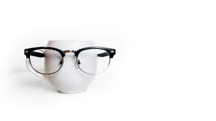 A cup of coffee and еуеglasses in a black frame, with a place for the text. Copy space. White background. Isolate.
