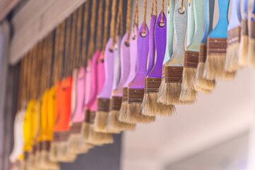 multi-colored brushes hang. Selective focus. background with paint brushes.