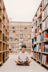 Child in school library. Kids read books. Little boy reading and studying. Children at book store. Smart intelligent preschool kid choosing books to borrow. © ganusik1304