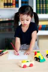 Little pretty pigtails hairstyle preschooler kindergarten girl sitting on chair drawing sketching...