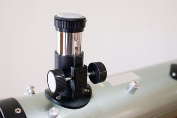 Rack and pinion focuser. Telescope parts on wooden table. Astronomy lesson exploring parts of...
