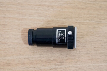 Barlow lens 2x for magnify. Telescope parts on wooden table. Astronomy lesson exploring parts of...