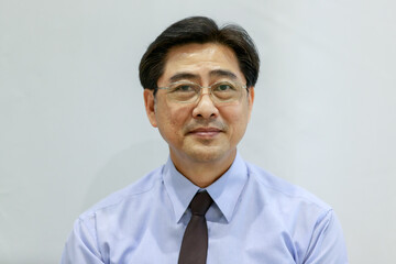 Portrait 50s healthy senior executive Asian businessman wearing glasses, shirt and necktie in a formal style, smiling happily and confidently in success, standing on white isolated background cutout.