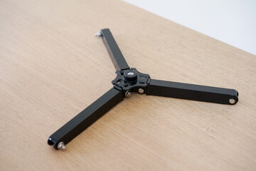 Tripod support bracket. Telescope parts on wooden table. Astronomy lesson exploring parts of telescope.
