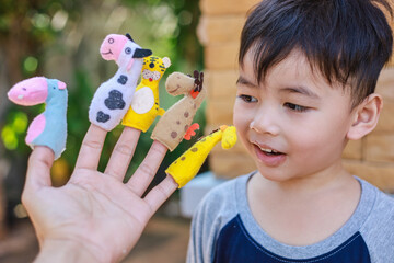 Lovely small man with doll puppets on her hands, smiling and playing