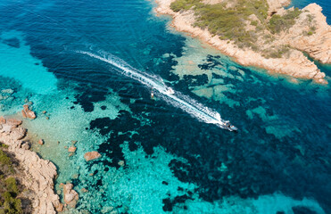 View from above, stunning aerial view of some boats sailing on a crystal clear, turquoise water. Giardinelli island, La Maddalena Archipelago, Sardinia, Italy.