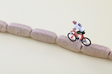 A doll model riding a bicycle on a calcium tablet