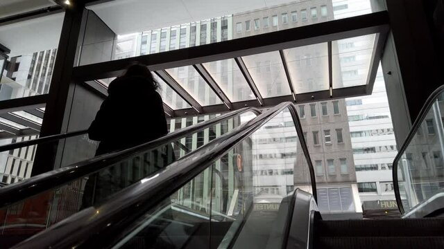 Woman Going Up By An Escalator Out Of The Wynyard Railway Sation In Sydney, NSW, Australia. - low angle