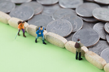 Miniature creative visitors watch piles of coins