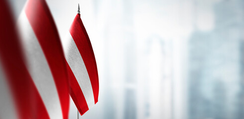 Small flags of Austria on the background of a blurred background - obrazy, fototapety, plakaty