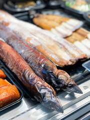 Smoked eel for sale in delicatessen deli counter in market hall in Sweden. Östermalmshallen. Rökt ål.