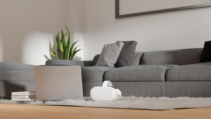 Comfortable modern living room, grey sofa, laptop computer and vr glasses on comfy carpet