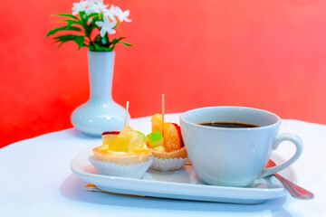 Afternoon snack set There was coffee in a white cup of coffee and two snacks beside it.