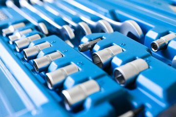 Fototapeta premium A set of tools for construction and repair in a blue case close-up. Shiny, metallic bits and wrenches close-up. Car service and hobby work.