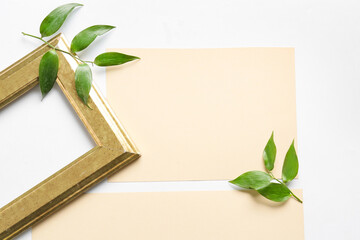 Composition with blank cards, empty picture frame and leaves on white background, closeup