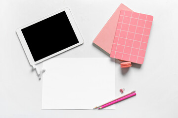 Composition with blank sheet of paper, tablet computer, earphones and stationery on white background