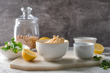 Obraz na płótnie Canvas Bowl with tasty hummus and lemon on table