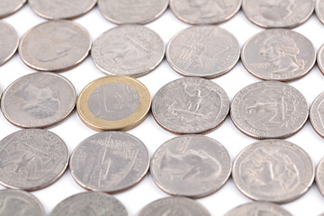 A Euro coin in a spread out dollar coin