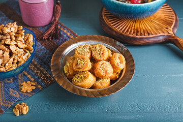 Plate with delicious baklava on color wooden background