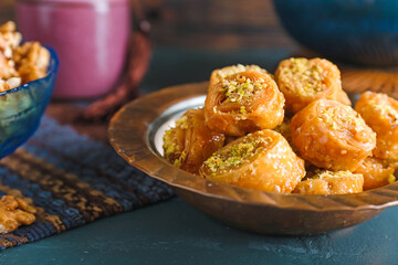 Plate with delicious baklava on color wooden background, closeup