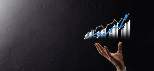 Businessman holding graph growth and increase of chart positive indicators in his...