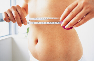 woman measuring their waist