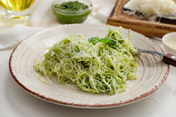 Plate with tasty pesto pasta on light background, closeup