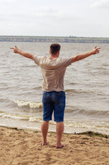Full-length portrait of a grown man standing on the riverbank. A