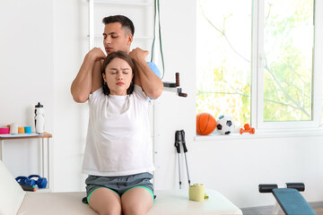Fototapeta premium Physiotherapist working with patient in rehabilitation center