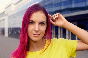 Beautiful girl with pink hair and a yellow T-shirt, horizontal portrait close-up