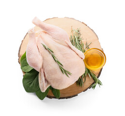 Board with whole raw chicken, oil, rosemary and spinach on white background