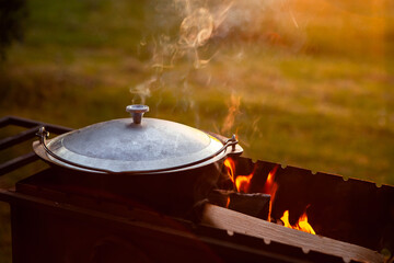 Cooking in a pot on the fire. Camping concept.
