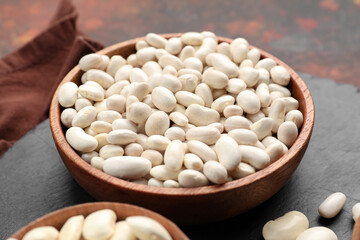 Fototapeta na wymiar Bowls with raw beans on table, closeup