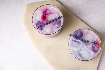 Glasses of fresh cocktail with lavender on light background