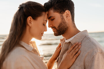 leisure, relationships and people concept - happy couple with closed eyes on summer beach