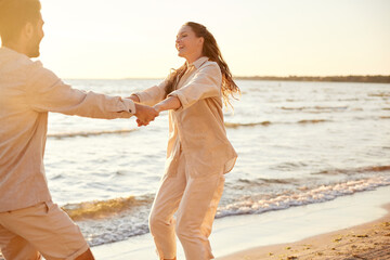 leisure, relationships and people concept - happy couple in sunglasses hugging on summer beach